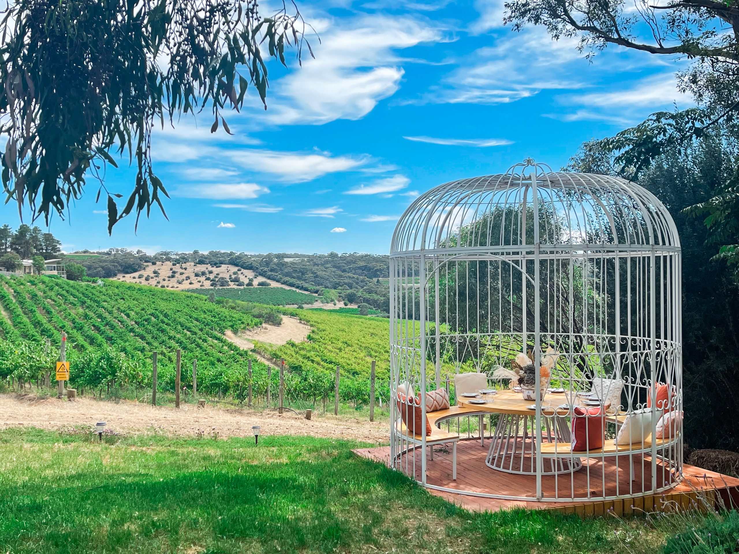 A large white birdcage seating area at Heidrun Estate cellar door and restaurant.